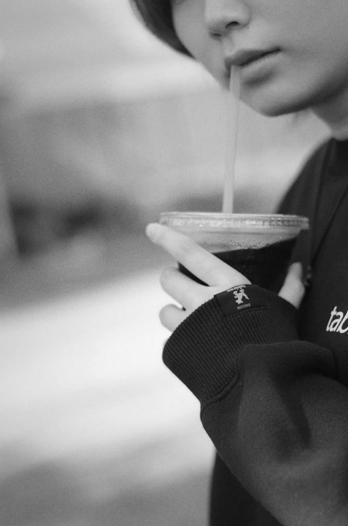 ドリンクを飲む手元のクローズアップ（モノクロ）