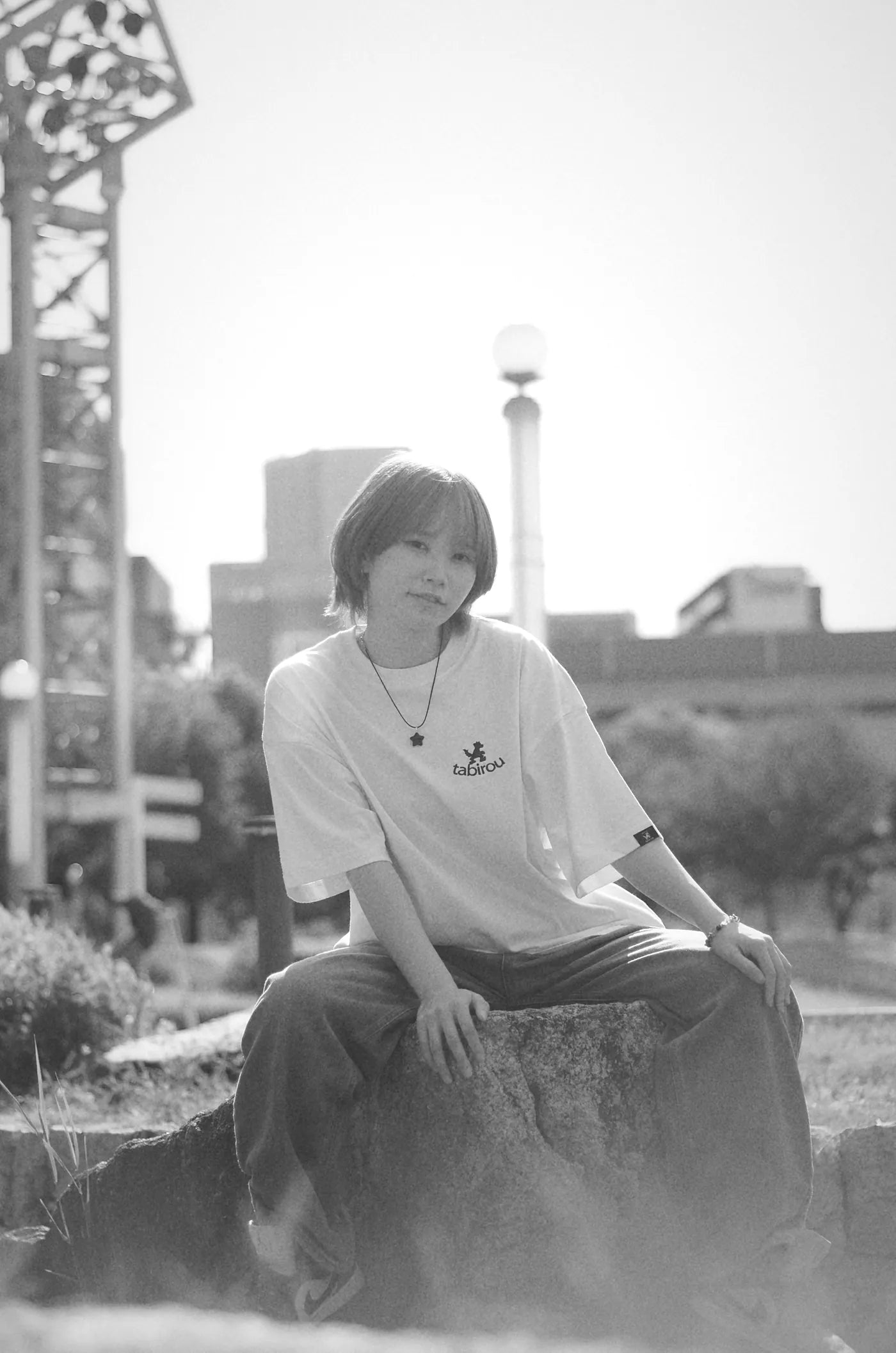 石に腰かけたポートレート（モノクロ）